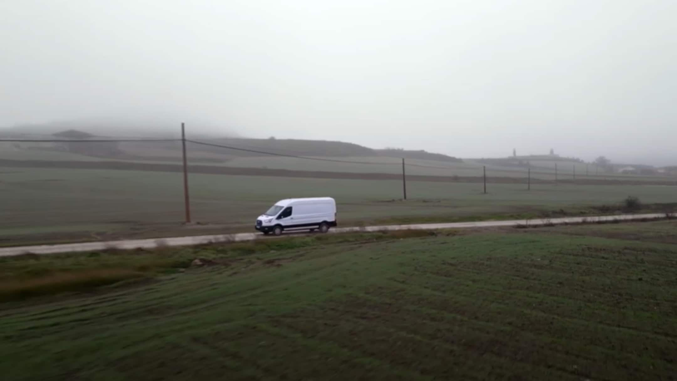 Ford E-Transit recorriendo carretera de campo