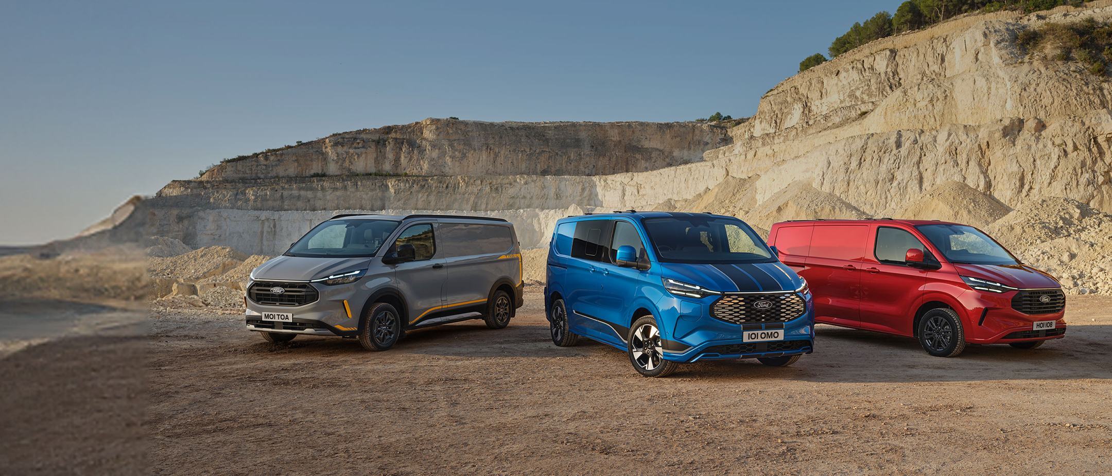 Three Ford Transit Custom Vans in grey, blue and red, parked side by side